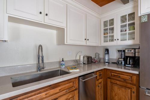a kitchen with white cabinets and a stainless steel sink at Fernwood in Arnold