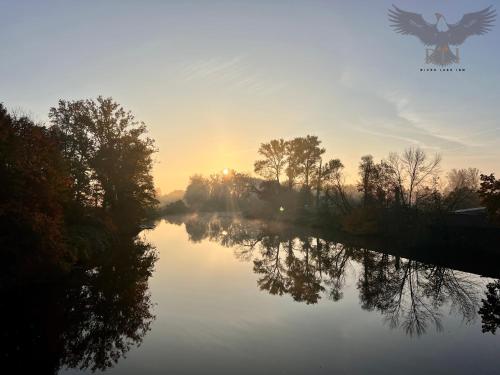 a view of a river with the sun setting at River Lake Inn - Muldestausee in Pouch