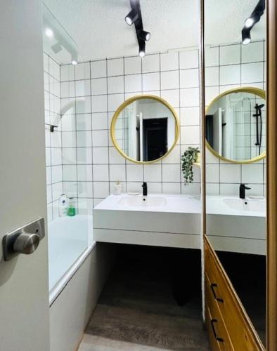 une salle de bain avec deux lavabos et deux miroirs dans l'établissement Résidence Squaw Valley - Studio pour 4 Personnes 991, à Aime La Plagne