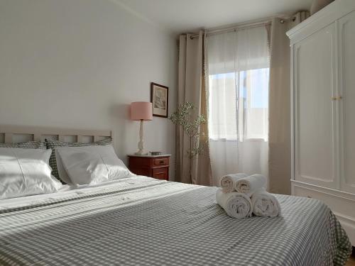 a bedroom with a bed with towels on it at Casa Buganvilia Penela - rooms near of the castle in Penela