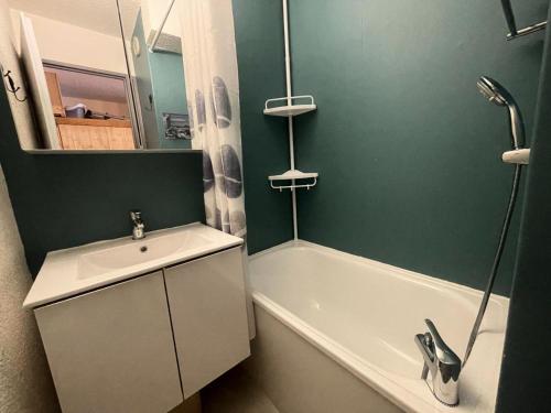 La salle de bains verte est pourvue d'un lavabo et d'une baignoire. dans l'établissement Résidence Arc En Ciel C - Coquet T2 face à la montagne et avec vue dégagée sur la 