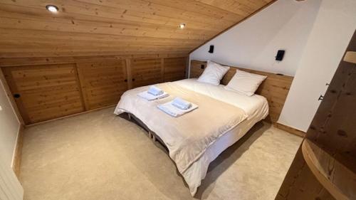 une chambre avec un lit avec deux serviettes dessus dans l'établissement Meribel, Appartement en duplex ski aux pieds refait à neuf, à Les Allues