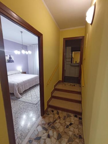 a room with a bed and a staircase with a mirror at La Casetta della fontana del muro in San Lorenzo Nuovo