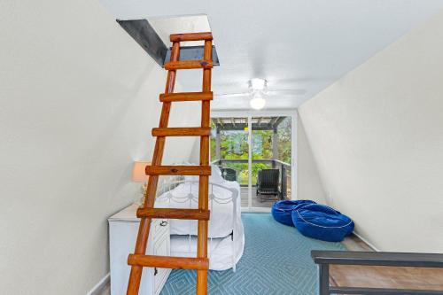 a loft bed in a room with a ladder at Lakeview A-Frame in Canyon Lake