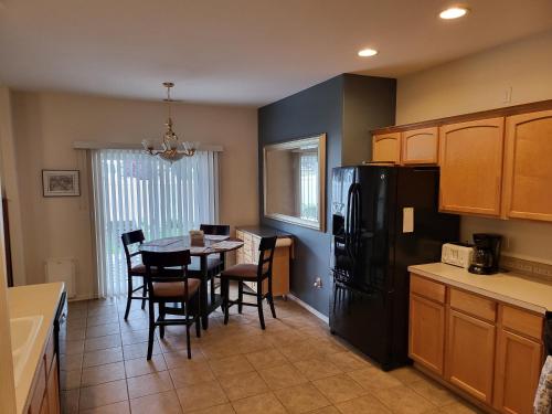 a kitchen with a table and a black refrigerator at Tri-Cities Home Away from Home in Richland