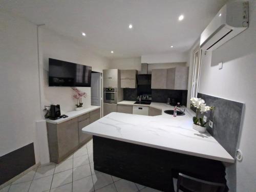 - une cuisine avec un comptoir blanc dans une pièce dans l'établissement Appartement 4 pièces - gare Nice riquier, à Nice
