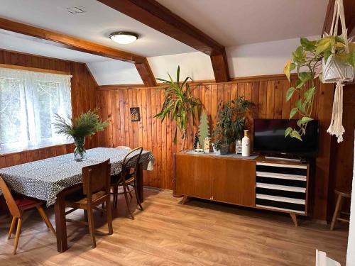 a dining room with a table and a television at Chata Jánošík in Terchová