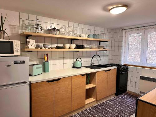 a kitchen with wooden cabinets and a white refrigerator at Chata Jánošík in Terchová