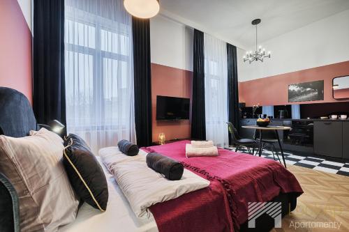 a room with a bed with pillows on it at Kolorova Apart by LookAp - darmowy parking w centrum Łodzi! in Łódź