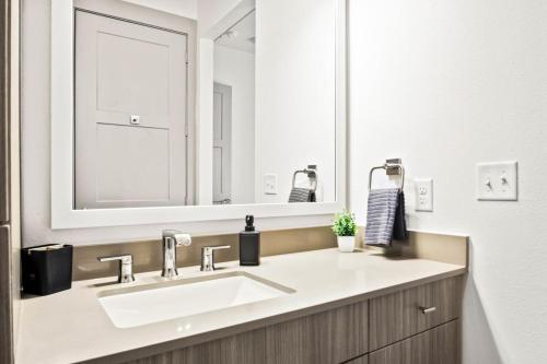 a bathroom with a sink and a large mirror at Luxurious New Unit 1Bd1BaPool, Golf Sim in Austin