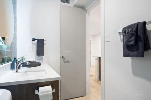 a white bathroom with a sink and a mirror at Brand New Unit, 5 min to Downtown Austin in Austin