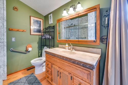 a bathroom with a sink and a toilet at Walk to Saylorville Lake Spacious Home with Deck! in Johnston