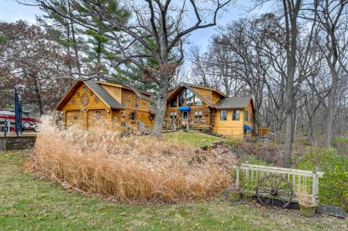 a large wooden cabin in the woods with a fence at Walk to Saylorville Lake Spacious Home with Deck! in Johnston