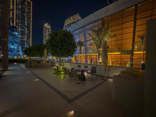 a patio with a table and chairs at night at The View of a Lifetime - Luxury Living with Full Burj Khalifa & Fountain Show - 1702 in Dubai