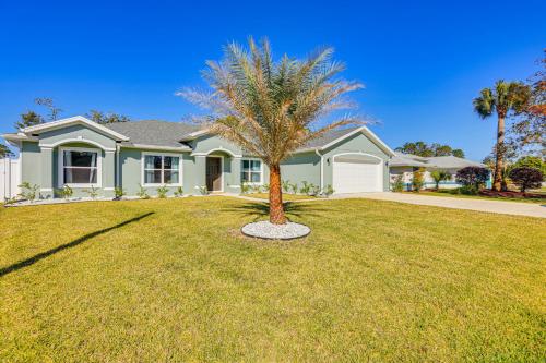 a palm tree in the front yard of a house at 8 Mi to Flagler Beach Home with Outdoor Dining! in Palm Coast