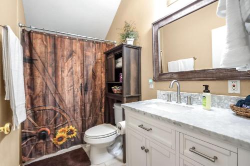 a bathroom with a wooden shower curtain and a toilet at Happy Hideaway in Wimberley