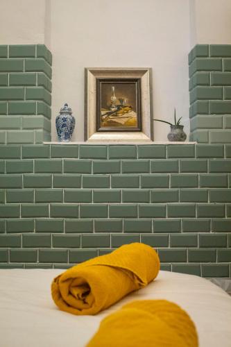 a bed with a yellow pillow in a room at Montijo Garden - Alojamento Rural in Montijo