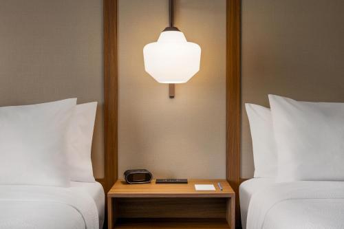 a room with two beds and a table with a clock on it at Fairfield by Marriott Inn & Suites Bethlehem PA in Bethlehem