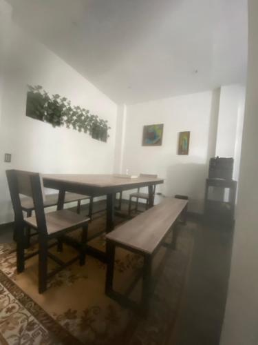 a dining room with a wooden table and benches at CandidoAIRPORT in Neiva