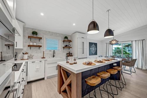 a kitchen with white cabinets and a large island with stools at Totally Beachin' in Bradenton Beach