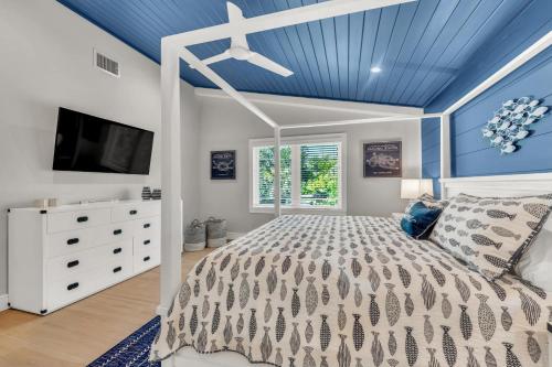 a bedroom with blue ceilings and a bed and a tv at Totally Beachin' in Bradenton Beach