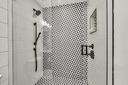 a bathroom with a shower with black and white tiles at Totally Beachin' in Bradenton Beach