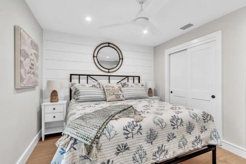 a bedroom with a bed and a mirror at Totally Beachin' in Bradenton Beach