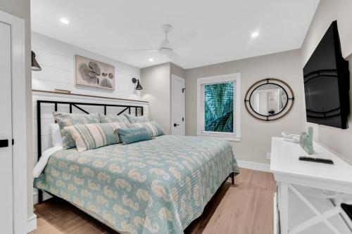 a bedroom with a bed with a television and a desk at Totally Beachin' in Bradenton Beach