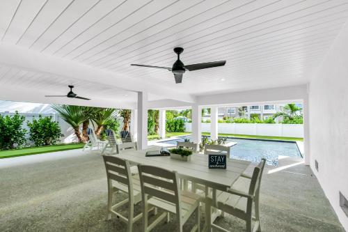 a white dining room with a table and chairs at Totally Beachin' in Bradenton Beach
