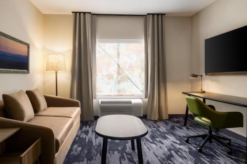 a hotel room with a couch and a desk and a window at Fairfield by Marriott Inn & Suites Bethlehem PA in Bethlehem