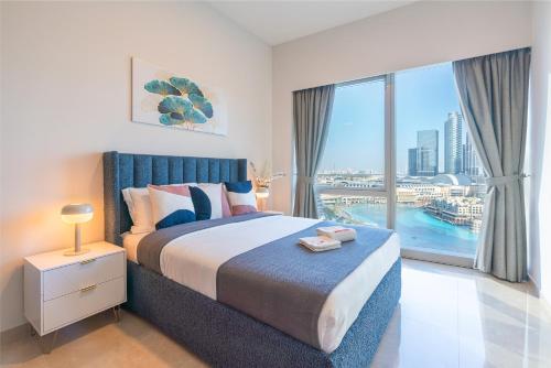 a bedroom with a large bed and a large window at Prime Location - Full Burj Khalifa & Dancing Fountains Show - 1704 in Dubai