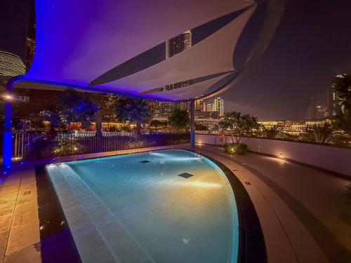 a swimming pool on top of a building at night at Prime Location - Full Burj Khalifa & Dancing Fountains Show - 1704 in Dubai
