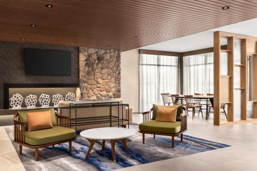 a lobby with chairs and tables and a tv at Fairfield by Marriott Inn & Suites Bethlehem PA in Bethlehem