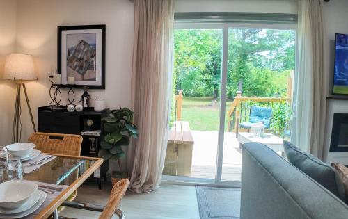 a living room with a glass table and a sliding glass door at Relax Near Chattanooga at cozy Magdelaine House in Fort Oglethorpe