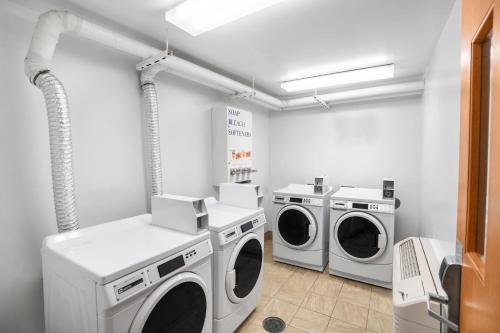 a laundry room with two washing machines and a sink at Holiday Inn Express & Suites Hayward by IHG in Hayward