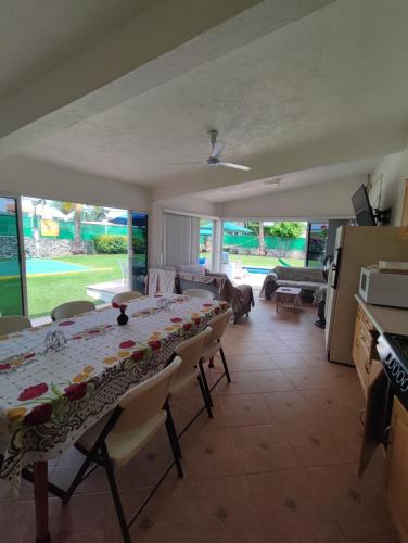 a dining room with a table and a living room at Bungalow Lomas de Cocoyoc in Oaxtepec