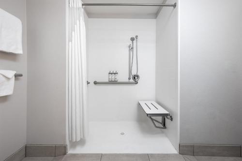 a white bathroom with a bench and a shower at Holiday Inn Express & Suites Phoenix West - Buckeye by IHG in Buckeye