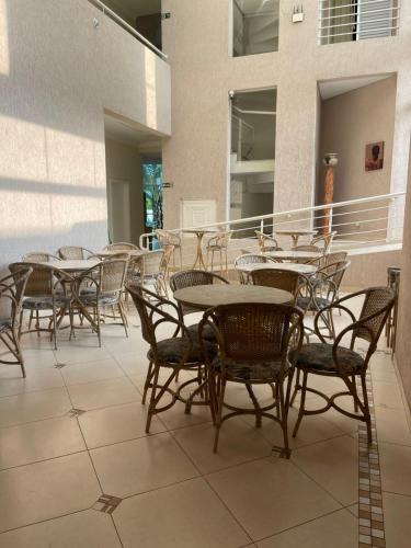 a group of tables and chairs on a balcony at Hotel Rosa da Ilha Guaruja - Perto do Mar com piscina in Guarujá