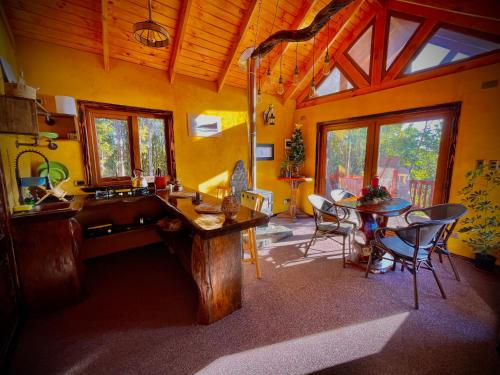 アンクードにあるCozzy Cabin at "Explore-Cafe & Lodge" Located in Duhatao, Chiloe Island, Patagonia, Chileのテーブルと椅子のあるキッチンとダイニングルーム