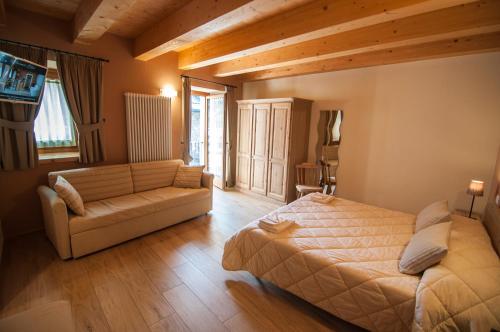 1 dormitorio con 1 cama y 1 sofá en L'Abrì, en Pietraporzio