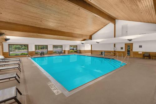 a large swimming pool in a building with a wooden ceiling at Holiday Inn Express & Suites Hayward by IHG in Hayward