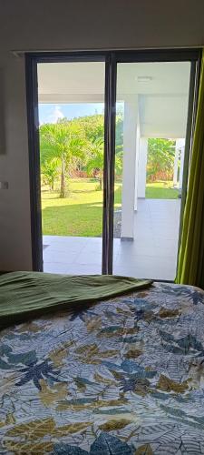 1 dormitorio con 1 cama y vistas al patio en Villa Matigwa, en Anse-Bertrand