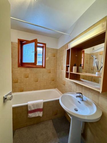 une salle de bain avec un lavabo et une baignoire et un lavabo dans l'établissement Appartement 4 personnes - Magnifique vue montagne, à Méribel