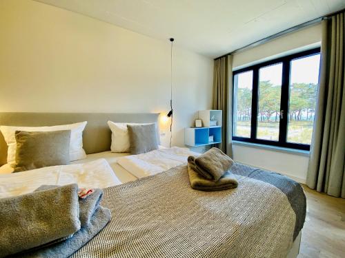 Ferienwohnung Proraloft 6 im Haus Prora Düne 7 في بينز: غرفة نوم بها سريرين ونافذة كبيرة
