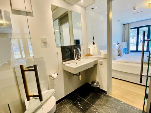 Ferienwohnung Proraloft 6 im Haus Prora Düne 7 في بينز: حمام مع حوض ومرحاض وسرير