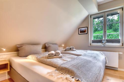 Un dormitorio con una cama con toallas. en Ferienhaus Inselliebe 02 Feriendorf Klein Stresow Rügen by ruyastay, en Putbus