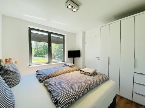 a bedroom with two beds and a window at Ferienwohnung Strandläufer Parkvillen Carlota und Candela Baabe in Baabe
