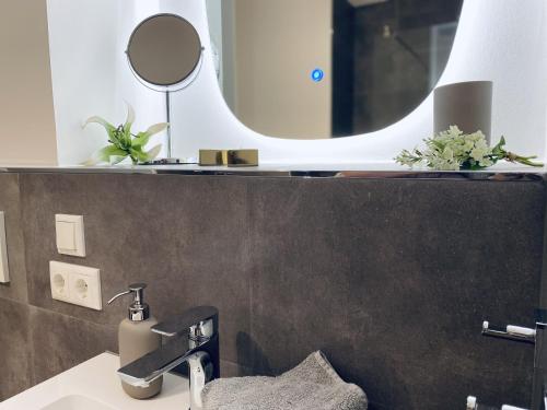 a bathroom with a sink and a mirror at Ferienwohnung Strandläufer Parkvillen Carlota und Candela Baabe in Baabe