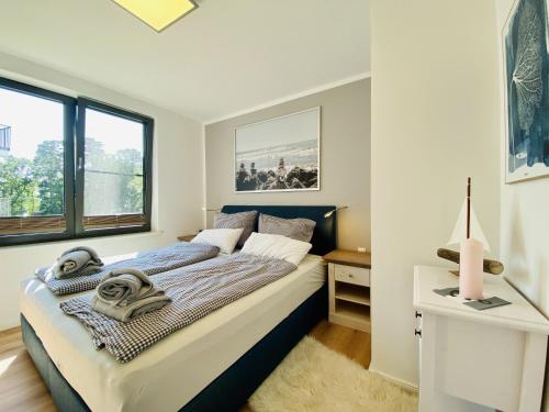 a bedroom with a bed and a window at Ferienwohnung Strandloper Parkvillen Carlota und Candela Baabe in Baabe