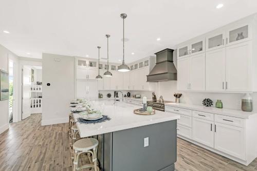 a white kitchen with white cabinets and a kitchen island at Coming In Hot in Holmes Beach
